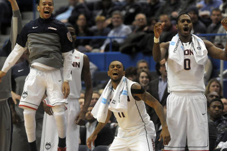 From left, University of Connecticut Huskies guard Shabazz Napier, 13, University of Connecticut Huskies guard Ryan Boatright, 11, and University of Connecticut Huskies forward Phillip Nolan, 0, cheer from the bench during the first half.