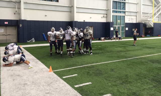 The UConn defense gets together after a drill during 2014 spring practice No. 4.