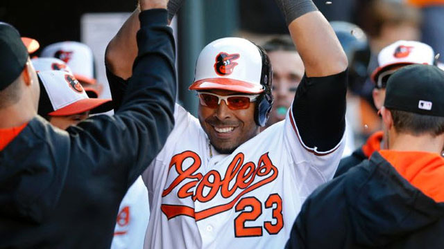 Baltimore Orioles' Nelson Cruz high-fives teammates in the dugout after hitting a solo home run in the seventh inning of an opening day baseball game against the Boston Red Sox, Monday, March 31, 2014, in Baltimore.