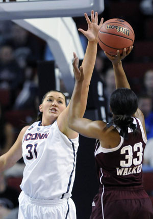 UConn center Stefanie Dolson defends a shot by Texas A&M guard Courtney Walker.