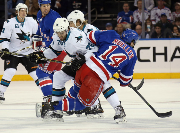  Eriah Hayes #76 of the San Jose Sharks checks Chris Mueller #14 of the New York Rangers to the ice during the first period at Madison Square Garden on October 19, 2014 in New York City. 