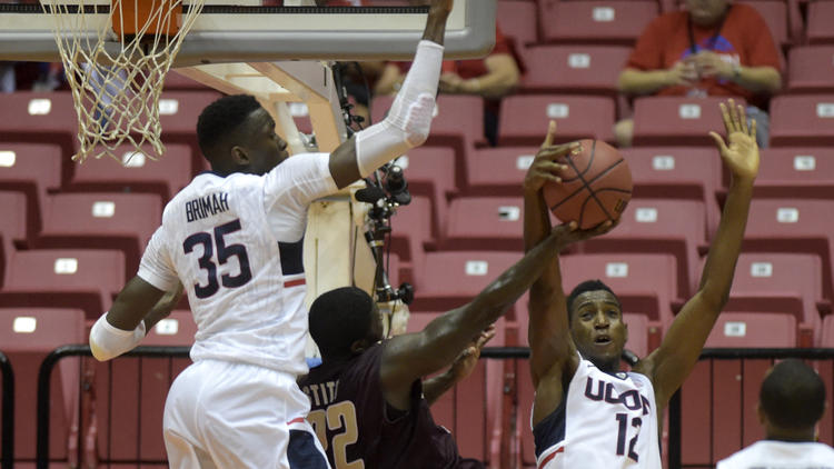 Amida Brimah (35) and Kentan Facey (12) of UConn keep Charleston's Anthony Stitt off balance in the first half on Thursday in a first-round game of the Puerto Rico Tip-Off tournament