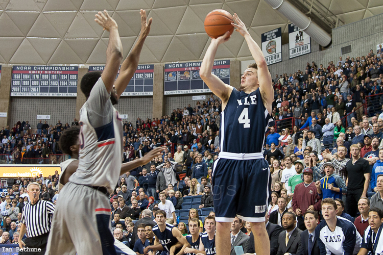 Yale G Jack Montague (4) puts up what turned out to be the winning three pointer over the outstretched arm of UConn G Sam Cassell Jr. (10) at Gampel Pavilion on December 5, 2014.