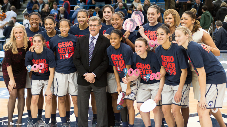     UConn head coach Geno Auriemma poses with his team after getting his 900th career win.